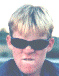 A person with light brown hair and a dark blue shirt appears in a of showing animated sunglasses changing styles