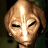 A pixelated contact sheet showing two frames of an animated icon featuring a humanoid alien face on the left and green text reading "Original Icons .com" on the right against a dark background.