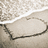 A heart shape drawn in sand on a beach with gentle waves rolling onto the shore.