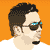 Pixelated profile of a person with dark hair, wearing sunglasses and a white shirt against an orange background.