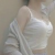 Pixelated figure in light-colored clothing with visible shoulder and arm details against a muted background.