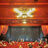 Pixelated image of a theater facade with a glowing marquee and dark entrance, surrounded by warm-toned architectural details.