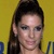 Pixelated close-up of a person with dark hair tied up, wearing a light-colored top against a yellow background with blue text fragments.