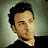 Pixelated image of a person with dark hair resting on a light pillow against a muted green background, next to blue text reading 'howie' on a cloudy sky backdrop.