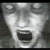 Pixelated grayscale face with wide eyes and open mouth, rendered in low-resolution blocky style against dark background.