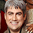 Pixelated image of a person with short gray hair smiling, wearing a brown jacket over a dark shirt, with text reading 'love him !!' on the right side.
