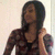 A static pixelated image of a person with long dark hair wearing a patterned top and carrying an orange strap over the shoulder against a light background.