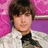 Pixelated portrait of a person with dark brown hair and light skin, wearing a white top with black collar against pink and purple background.
