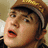 A pixelated image of a person wearing a brown cap with a white stripe, showing two states: one with no text and one with green text above the head.