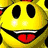 Yellow cartoon character with black eyes, red tongue sticking out, and a wide smile.