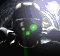 Animated sequence showing a dark helmeted figure with green eye lights and white accents, emitting colored beams from its eyes.