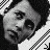 Black-and-white pixelated image of a person with dark hair, wearing a light-colored shirt and dark jacket, viewed from the side.