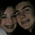 Two pixelated human faces in close proximity, both smiling broadly with visible teeth against a dark background.