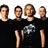 Four people in black shirts stand against a white background with text reading "I want to be that someone that you with" in pixelated white letters on black.