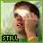 A pixelated image of a person with short dark hair, wearing a yellow top and holding their hand near their face. The left side shows 'STILL' text while the right side shows 'HOT' text.