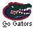 Pixelated green alligator head with red outline and blue accents, mouth open showing white teeth, below text reading 'Go Gators' in blocky font.