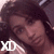 A pixelated image of a person with long dark hair wearing a light-colored checkered shirt, showing two sequential poses.