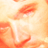A low-resolution, pixelated static image with warm orange and white tones showing an indistinct figure or object against a gradient background.
