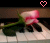 A pixelated image of a pink rose with green leaves on piano keys, featuring two heart symbols above the scene.