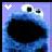 Pixelated blue cartoon character with large eyes and a dark mouth area against a light purple background, featuring a small white heart symbol in the top-left corner.