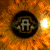 A circular icon with a dark center containing a stylized 'A' symbol, surrounded by a fiery orange and brown gradient background with a bright white glow on the right side.