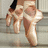 Pixelated image of a person's lower body wearing light-colored shorts and dark footwear, standing on a textured surface.