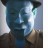 Pixelated static image of a person's face with blue and white tones, dark hair, and a blurred background.