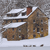 Pixelated image of a brown house with white trim and a red chimney against a gray background.