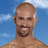 A pixelated image of a shirtless man with a bald head and goatee against a blue sky background, with red text reading 'Muy Caliente!' on the right side.