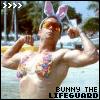 A shirtless man with bunny ears flexes his biceps on a beach, wearing sunglasses and a colorful floral lei under the text "BUNNY THE LIFEGUARD".