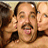 A static pixelated image shows a person with dark hair and mustache in the center, flanked by two other figures against a light background.