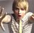 Pixelated static image of a person with light brown hair wearing a white shirt and dark tie, holding a white object in the left hand.