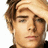 Pixelated close-up of a person's face with light brown hair, neutral expression, and visible ear, set against a plain white background.
