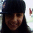 Pixelated static image of a person wearing a dark cap and long dark hair, with a blurred background showing a small red and white shape.