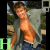 A shirtless man in a gray jacket and blue jeans stands outdoors with greenery behind him, as the word "HOT" appears sequentially below.
