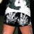 A person in a green and white sports jersey with number 9, gray shorts, and orange skin, viewed from behind with hands on hips.