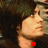 A pixelated image of a person with dark hair and a red heart symbol near the neck, shown in three with slight head position changes