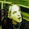 A person with long dark dreadlocks and red streaks appears in multiple poses against a green background, wearing black clothing.