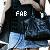 A pixelated image of a person in dark clothing and light blue denim, with text overlays showing partial letter combinations.