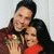Two people embrace in a close-up pose; one wears red clothing, the other dark hair and brown tones.