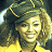 A pixelated contact sheet showing two frames of an animated icon featuring a person with curly hair wearing a dark cap and yellow clothing on the left, next to green text reading "Original Icons .com" on a dark background.