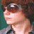 Pixelated static image of a person's face in profile with brown hair and light skin tone against dark background.