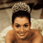 A person with short dark hair wears a towel on their head, smiling in front of a green background displaying 'OriginalIcons.com' text.