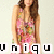 A pixelated image of a person with long brown hair wearing a pink floral-patterned sleeveless dress, standing against a light background with partial text visible at the bottom.