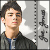 A static image shows a person with short dark hair wearing a dark jacket over a blue shirt, with handwritten text on the right side.