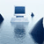 Pixelated static image showing a computer setup with a monitor, keyboard, and mouse on a light blue background.