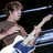 Pixelated image of a person playing electric guitar with text overlays on black background.