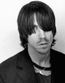 Black-and-white portrait of a person with dark hair and a dark jacket, overlaid with 'I Love' text in a rounded font, displayed in a of three vertical