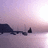Pixelated landscape with dark landmasses against a gradient sky transitioning from purple to pink and white.