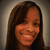 Pixelated close-up of a person with long dark brown hair, smiling broadly against a gradient background.